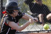 Lawrence High's Katie Murrish (12) lays down a bunt against Shawnee Mission East Thursday, April 4, 2013 at LHS.