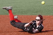 Lawrence High second baseman Kenzie Garvin hits the ground attempting to reach an infield hit in the Lions' doubleheader split with Shawnee Mission East on Thursday, April 4, 2013 at LHS.