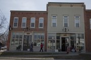 Shoppers peruse store windows at Seventh and Locust streets on a Friday afternoon. The corner is gaining an identity as a destination neighborhood for antiques and home decor, with several stores now open in the historic North Lawrence buildings.