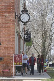 Shoppers peruse store windows at Seventh and Locust streets on a Friday afternoon. The corner is gaining an identity as a destination neighborhood for antiques and home decor, with several stores now open in the historic North Lawrence buildings.