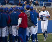 Kansas' Alex DeLeon, right, is congratulated by teammates after blasting a home run to give Kansas the lead during Kansas' game against Texas on Friday, April 12, 2013, at Hoglund Ballpark.