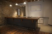 A 4,000-square-foot cider vinegar factory built in the 1890s at 810 Pennsylvania St. has been renovated and will celebrate its grand opening Friday. The new Cider Gallery features an art gallery and event space — including this bar made with reclaimed wood from the nearby Poehler Lofts building — on the first floor, an "Entrepreneur Office Hub" upstairs and an adjacent outdoor event space, which is still under construction.