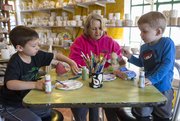 Payton Pringle, 3, right, and his brother Dakota, 6, work on painting Mother's Day gifts while their grandmother Kim Wampler works on her own project at Sunfire Ceramics, 1002 New Hampshire St. Wampler and her grandsons live in Lawrence.