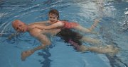 Tyghe Nielsen, a former Kansas University swim team member, gives Ansley Ross, 6, of Overland Park, a ride at the Drown Out Cancer Swim-A-Thon held on Saturday at the Lawrence Indoor Aquatic Center. Nielsen organized the event to raise money for the KU Cancer Center and the Kanzius Cancer Research Foundation. Three years ago, Nielsen was diagnosed with stage 4 colorectal cancer with metastasis to his liver, a cancer with only an 8 percent chance to be alive five years after a diagnosis.