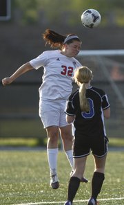 Lawrence High's Danielle Campbell heads the ball over Leavenworth's Megan Besmer during the first half, Thursday, May 9, 2013, at Lawrence High.