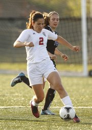 Lawrence High's Sadie Keller competes for the ball against Leavenworth's Alexa Allen during the first half, Thursday, May 9, 2013, at Lawrence High School.