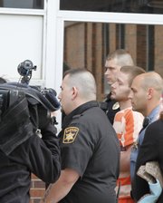 Kyle T. Flack, 27, is transported from the Franklin County courthouse Friday after being charged with four counts of murder and one count of rape. Flack is being held on a $10 million bond.