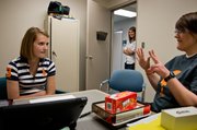 Molly Ogden, left, concentrates on the order of numbers as she counts to 20 for speech language pathologist April Jardes at the Rehabilitation Institute of Kansas City. Molly's mother, Alison, watches from the doorway.