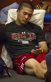 Kansas sophomore Justin Protacio checks his phone after learning that the Jayhawks did not make it into the NCAA baseball tournament. The team gathered Monday, May 27, 2013, at the Hoglund Ballpark clubhouse to watch the tournament selection show.