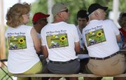 Wearing matching Hoover Reunion T-shirts, from left, Barbara Hoover Pekema, her husband, John Pekema, of King City, Calif., and Ben Ebenhack, of Marietta, Ohio, look out from the lunch table during the Hoover Family Reunion on Saturday at Lone Star Lake. In 1855, pacifist ancestors of the Hoover family settled in Douglas County. Almost 180 relatives from 18 states converged on Douglas County for the family’s 100th family reunion this weekend.
