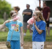 Cousins Carolyn Hoover, 10, of Eudora, left, and Maddie Steele, of Kearney, Neb., keep the conversation short as they bite into their cotton candy during the Hoover Family Reunion on Saturday at Lone Star Lake. The two girls, who had never met before this weekend, are among the almost 180 people from 18 states to converge on Douglas County for the Hoover family's 100th family reunion. Ancestors of the Hoover family settled in Lawrence in 1855.