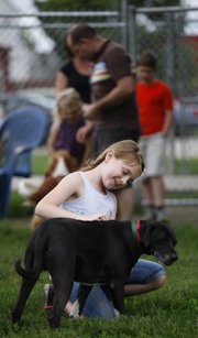 Eight-year-old Lottie Keating pets Tad, a mixed-breed dog, during a meet and greet before adopting him on Saturday at the Lawrence Douglas County Humane Society, 1805 E. 19th St.