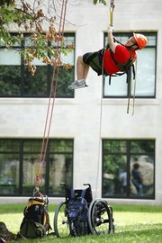 Devan Glenny, a college senior from Lebanon Valley College in Annville, Pa., leaves his wheelchair on the ground as he ascends into a tree Thursday on the Baker University campus. Eight research interns were selected from across the country to participate in a 10-week, canopy-research project funded by the National Science Foundation. The interns will be climbing the trees at various heights to collect moss and lichen samples for measuring the density and diversity of microscopic animals called tardigrades. Glenny, who is interested in pursuing a career that involves field research, says he was drawn to the project when he found out it was open to students with wheelchairs.