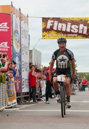 Lawrence’s Dan Hughes crosses the finish line after winning his third straight — and fourth overall — Dirty Kanza 200, a 202-mile bike race around Emporia. Hughes three-peated on Saturday.