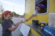 England Porter, Lawrence, right, one of the co-owners of the Blissful Bite food truck, hands Amy Oelschlaeger, Lawrence, an order of quesadillas during the annual Relay for Life event, held Friday, June 7, 2013, at Free State High School.