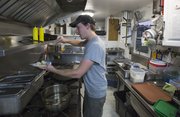 Tristan Landwehr, Lawrence, one of the co-owners of the Blissful Bite food truck, makes a gluten-free taco during the annual Relay for Life event, held Friday, June 7, 2013, at Free State High School.