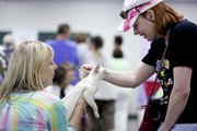 St. Louis resident Kathy Becker holds her Tonkinese cat, Crystal, as Shawnee resident Julie Grindol reaches down to scratch her neck during the Kansas City Midwest Cat Club Show, Saturday June 15, 2013 at the Douglas County Fairgrounds.
