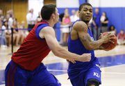 Blue Team guard Frank Mason drives against Red Team guard Tyrel Reed during a scrimmage before the basketball campers on Wednesday, June, 19, 2013 at the Horejsi Center.