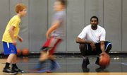 Kansas forward Justin Wesley watches as campers work on setting picks, Monday, June 24, 2013 during the Cole Aldrich basketball camp at Olathe Northwest High School.