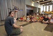 Nikolas Colom of the KU Robotics Club waits for his assistant to power up the propellers on a quadrotor robot during a presentation for 5- and 6-year-olds attending the library's Kidsapalooza activity on Monday, June 24, 2013, at the Carnegie Building.