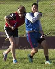 Kansas junior Chris Fellows, Kansas City, Mo., left, tries to wrestle the ball away from senior Hai Nguyen during a quidditch practice Wednesday, April 24, 2013 behind Robinson Gymnasium on the campus of Kansas University.