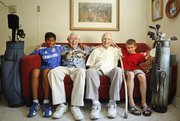 After over 60 years of golfing together, friends Dick Schiefelbusch, 94, left of center, and Al Gallop, 97, who have known each other since World War II, have passed their clubs on to beginners Kanak Masten, 11, left, and Salvador Good, 10, respectively, with hopes that the two can have fun with the game but also build friendships in the process. The four are pictured on Thursday, July 11, 2013 at Presbyterian Manor, 1429 Kasold Drive, where the two gentlemen live. Nick Krug/Journal-World Photo