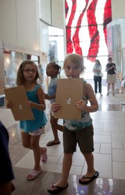 A group of children from the Boys and Girls Club start off on a scavenger hunt at the Dole Institute of Politics at Kansas University during a celebration for Bob Dole's 90th birthday Monday. Cake was served and kid-friendly activities were hosted by the institute.