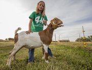 Eight-year-old Halley Flory, Baldwin City, stands with her goat, Chip, as he lets out a call after taking a short walk. Halley raised Chip to show at the Douglas County Fair.