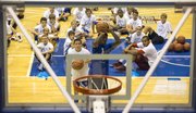 Eleven-year-old Chris Fields waits for his turn to shoot as he and former Kansas University player Ben McLemore duel it out in a game of knockout as other campers watch during the Bill Self basketball camp Saturday at Allen Fieldhouse.