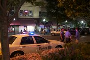 Police officers talk with a college student in the 700 block of Massachusetts Street early Friday morning. Several officers have been detailed to work downtown and in other party hotspots in an effort to curb dangerous behavior associated with alcohol as a new school year begins at local universities.