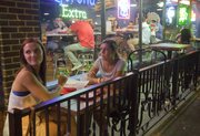 KU seniors from Topeka, Kelly Wayner, left, and Bethany Hughes, eat on the patio outside Fuzzy&squot;s Taco Shop, 1115 Massachusetts St., after midnight Friday, August 30, 2013. "It&squot;s sort of my go-to spot," said Hughes of the late-night food stop.