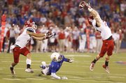 Kansas receiver Rod Coleman watches a pass get nearly intercepted by South Dakota safety Ryan Alger during the third quarter on Saturday, Sept. 7, 2013 at Memorial Stadium. At right is South Dakota defensive back Steve Tellefsen.