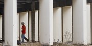 Where windows, walls and books used to be, a worker moves through the empty interior of the Lawrence Public Library during the continuing construction and renovation on the building earlier this year.