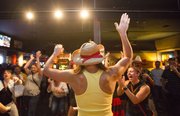 Michelle Kogl, Lawrence, raises her arms as she's introduced to the crowd before competing in a roller cycling race at Franks North Star Tavern, 508 Locus Street, on Friday, Sept. 13, 2013.
