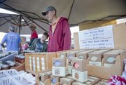 Courtney Skeeba of Homestead Ranch in Lecompton and her son, Marek, sell their handcrafted goat butter soaps at the Lawrence Farmers Market.