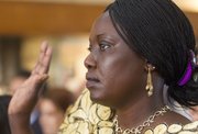 Originally from South Sudan, Ayak Mawin, of Olathe, takes the oath of citizenship during a naturalization ceremony Tuesday morning at the Dole Institute of Politics.