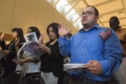 Originally from Colombia, Leonardo Polo, of Kansas City, takes the oath of citizenship during a naturalization ceremony Tuesday morning at the Dole Institute of Politics.