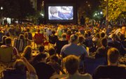 Hundreds of people flooded Massachusetts Street Thursday evening to watch the 1980s movie, The Goonies, on a large, portable movie screen set up at 11th and Massachusetts Streets.