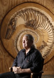 Fossil hunter Alan Detrich, Overbrook, is pictured with a 17-foot Mosasaur, he discovered several years ago in Gove County, Kansas. Detrich, who has uncovered various dinosaur fossils says it took him a year to clean and set the Mosasaur within masonry molding plaster as it is seen. Nick Krug/Journal-World Photo