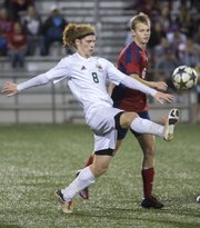 Free State's Alex Trent (8) kicks the ball away from Olathe North's Jack Chalfant (6) during their soccer match Thursday at FSHS.
