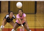 Lawrence High's Caitlin Broadwell, right, receives a serve while teammate Jessica Lemus watches during their volleyball match Thursday at LHS.