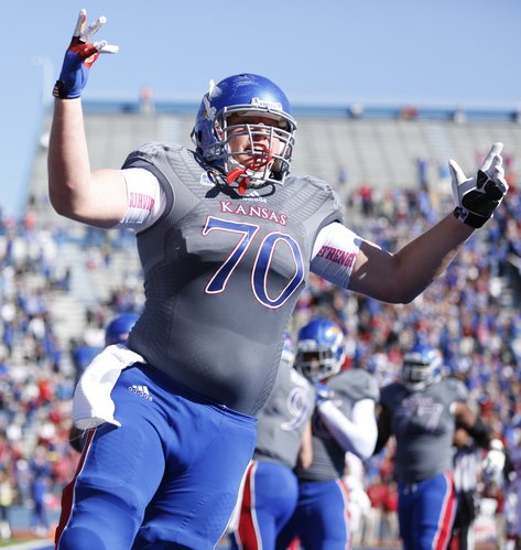 Kansas offensive lineman Gavin Howard raises up the crowd after tight end Jimmay Mundine's touchdown against Oklahoma during the first quarter on Saturday, Oct. 19, 2013 at Memorial Stadium.