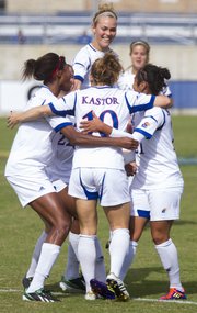 Kansas forward Caroline Kastor (10) is mobbed by teammates following her first half goal during their game against Baylor, Sunday at the Jayhawk Soccer Complex.