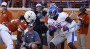 Kansas safety Isaiah Johnson is looks to break away from Texas receiver Marcus Johnson after intercepting a pass during the fourth quarter on Saturday, Nov. 2, 2013 at Darrell K. Royal Stadium in Austin, Texas. Johnson intercepted two passes in the 35-13 loss.