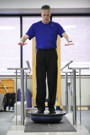Lawrence resident Sam Porritt balances himself during a therapy session on Wednesday at Lawrence Memorial Hospital.
