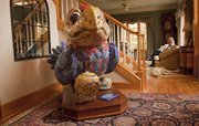Debbie Zabel and the family dog rest in their living room, just beyond “Chip Off the Old Hawk," which she and her husband Michael purchased at a charity auction after the 2003 Jayhawks on Parade project. Other items in Michael Zabel&squot;s KU memorabilia collection decorate his study and a basement recreation room.