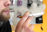 FILE - A sales associate demonstrates the use of a electronic cigarette and the smoke like vapor that comes from it in Aurora, Colo. on Wednesday, March 2, 2011. Children - like adults - are increasingly trying electronic cigarettes, according to the first large national study to gauge use by middle and high school students. About 2 percent of the students said they’d used an e-cigarette in the previous month, according to a survey done in 2012. That was up from 1 percent in 2011. Results were released Thursday, Sept. 5, 2013 by the Centers for Disease Control and Prevention.