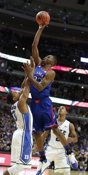 Kansas forward Andrew Wiggins floats for a shot over Duke guard Tyler Thornton during the second half of the Champions Classic matchup on Tuesday, Nov. 12, 2013 at the United Center in Chicago.
