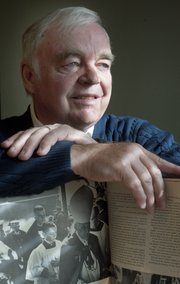 Reaumur Donnally of Lawrence remembers President John F. Kennedy. He he was an altar boy at Kennedy's funeral. He holds an Associated Press book on Kennedy, showing him as a child, following Cardinal Richard Cushing.