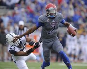 Kansas quarterback Montell Cozart pushes aside West Virginia safety Darwin Cook on a run during the first quarter on Saturday, Nov. 16, 2013 at Memorial Stadium.